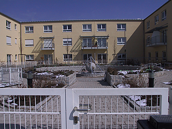 Blick von der Haupteingangspforte in den Garten der Begegnung. In der Bildmitte der Weltkugelbrunnen.